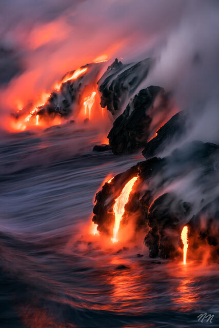 Molten lava flowing into the Pacific Ocean at Hawaii Volcanoes National Park on the Big Island, with steam, ocean waves, and glowing lava rock.