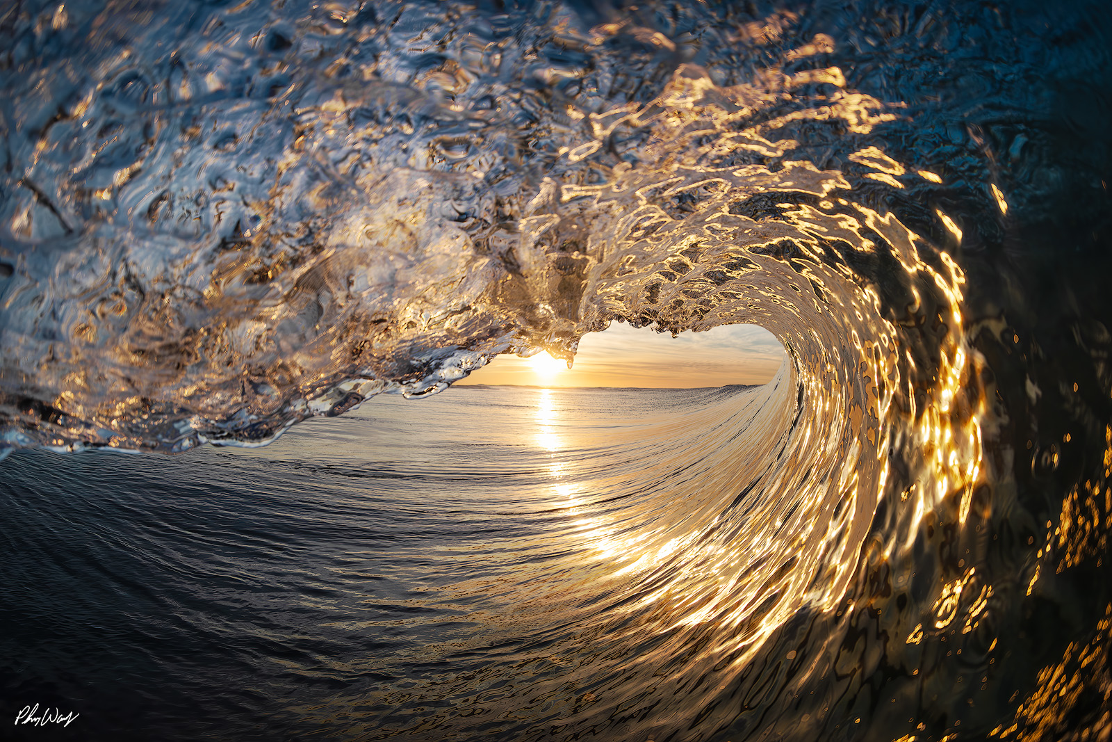 Sunrise Special Golden sunrise light shining through the inside of a hollow ocean wave in Oxnard, California.